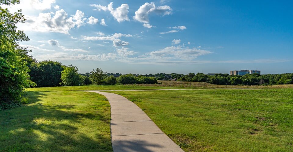 Auburn Hills trail concrete path with landscaping and green grass
