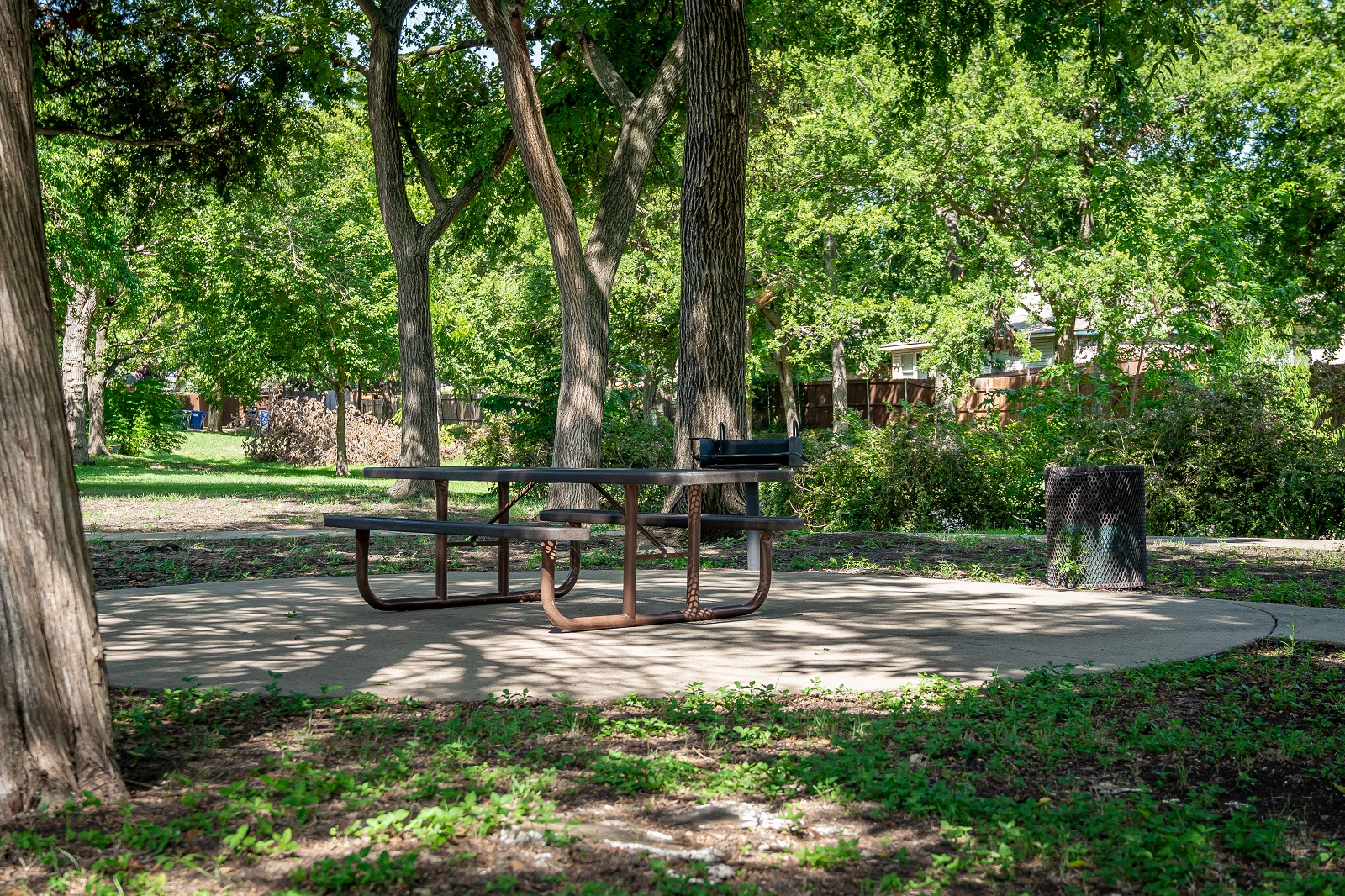 E.L. Tinker Taylor memorial park with green grass, picnic tables, trees, and a walking path