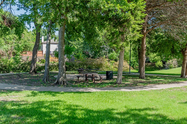 E.L. Tinker Taylor memorial park with green grass, picnic tables, trees, and a walking path