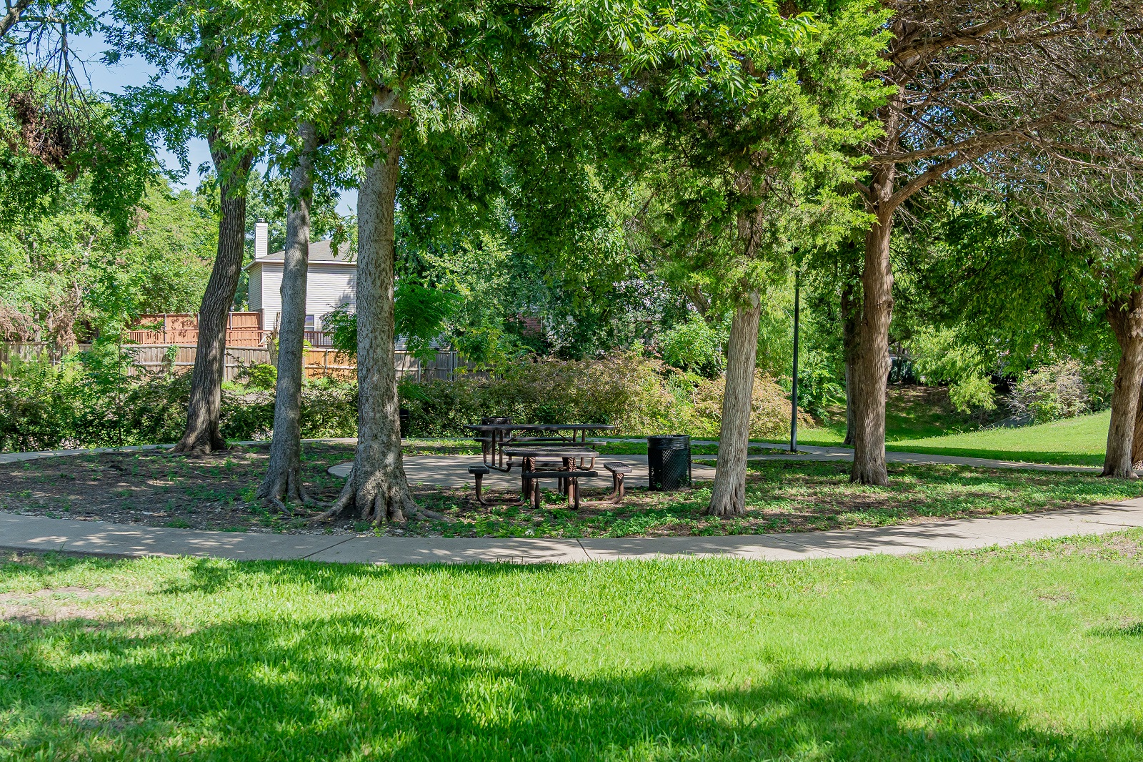 E.L. Tinker Taylor memorial park with green grass, picnic tables, trees, and a walking path
