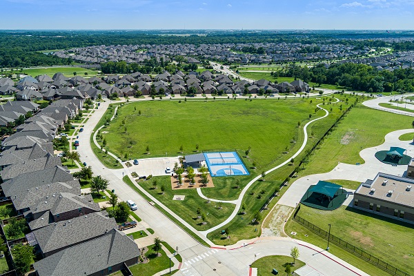 Forest Ridge park aerial of the park with green grass, walking path, playground, multi-sport courts.