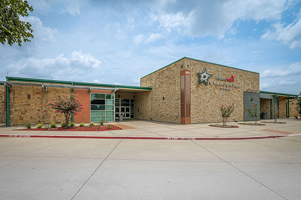 Single-story building with stone and brick exterior, labeled “Stark Elementary School,” set against a partly cloudy sky with minimal landscaping in front.