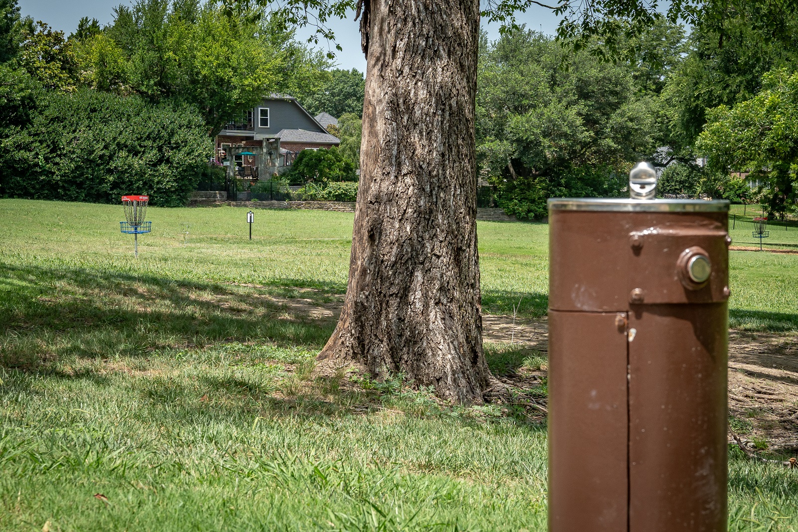 alex clark disc golf course with basket in the background and a water fountain up close