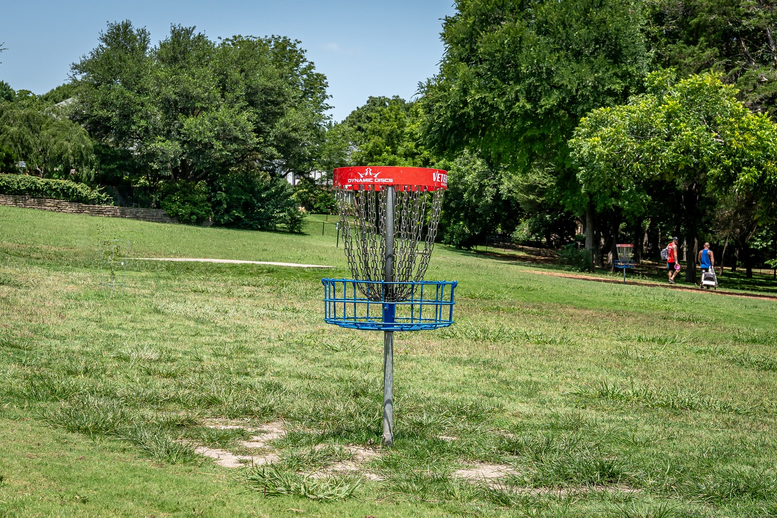 alex clark disc golf course with a basket in the middle of the green grassy field