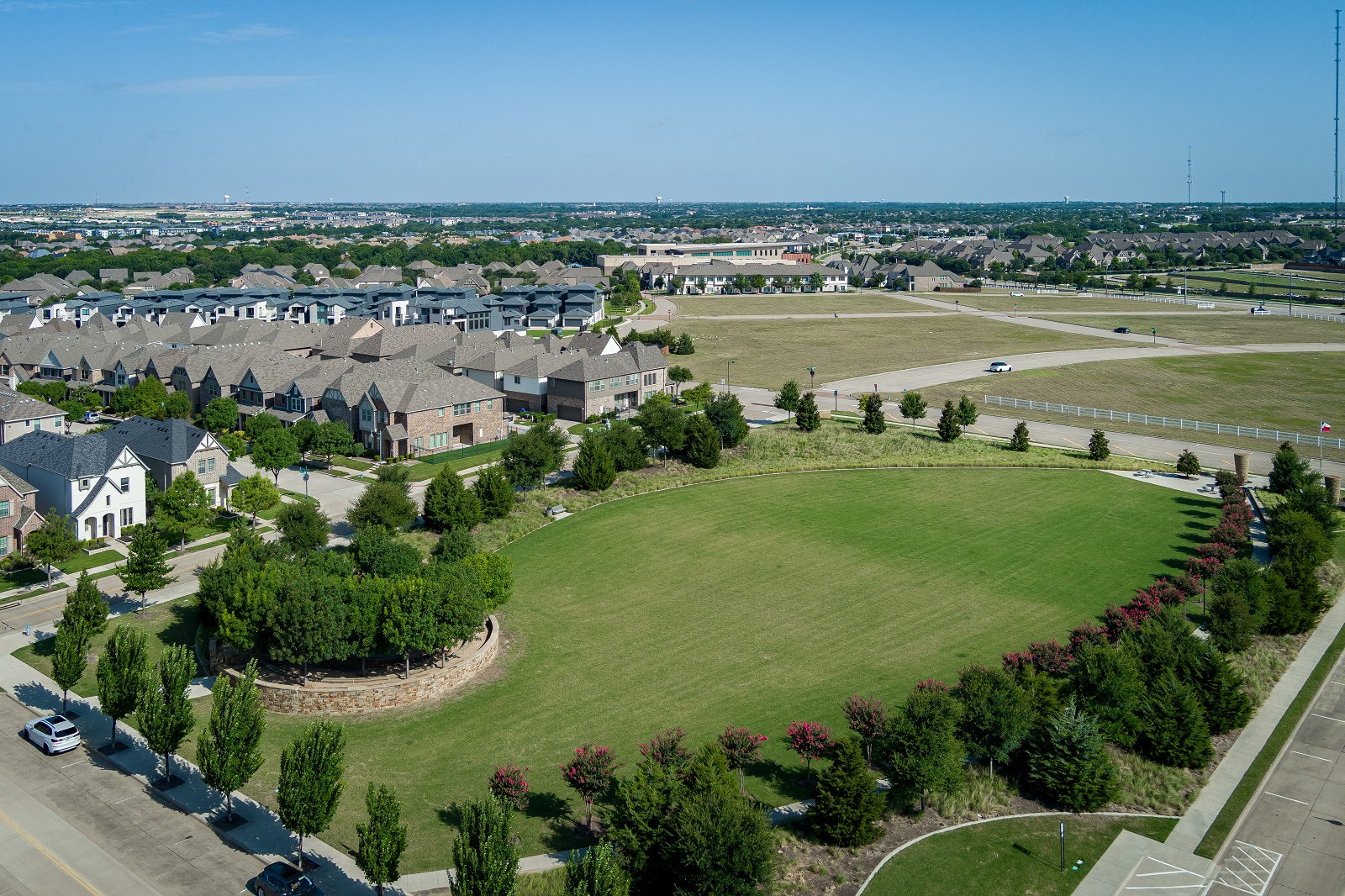 Crescent park aerial photo with grassy green field with trees surrounding it